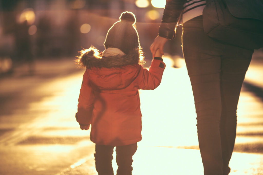 CAWN guide for parents: a parent holding a young child's hand on a sunlit street