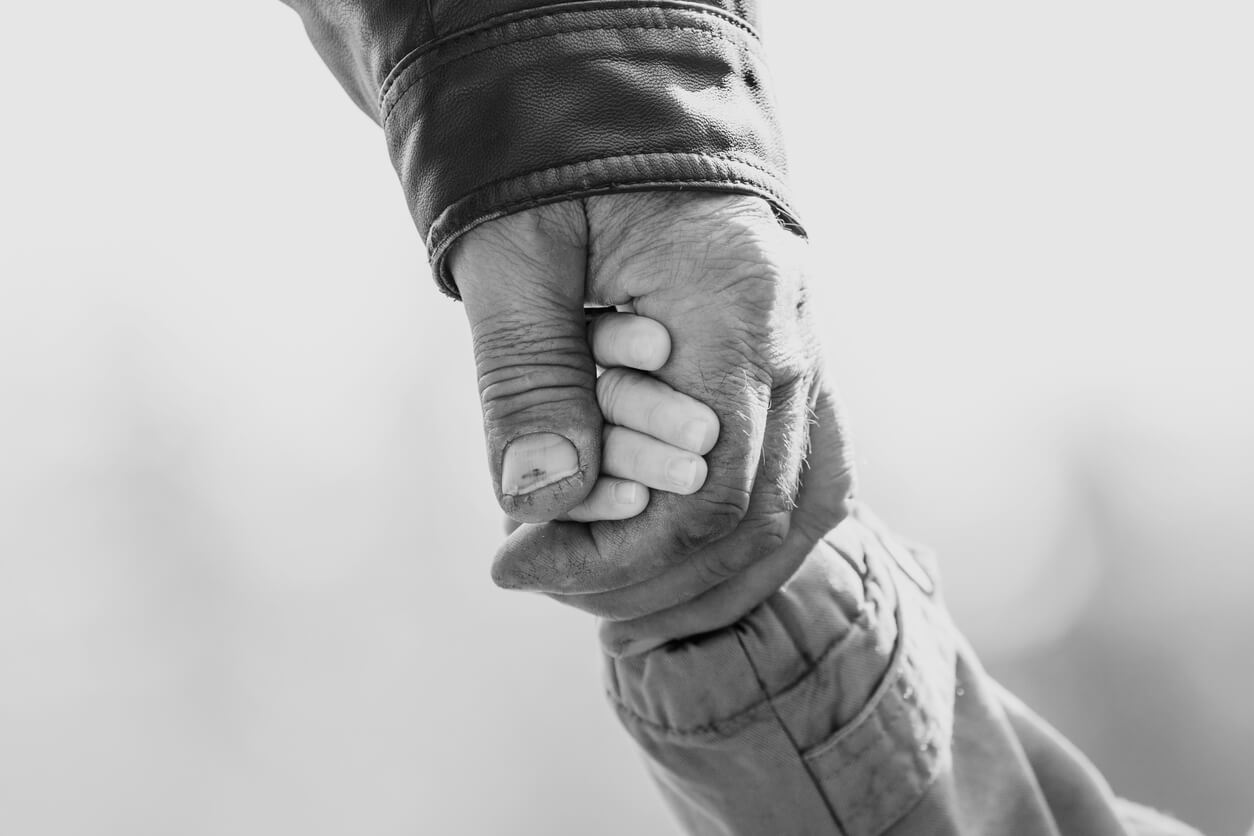 Pre-birth assessment and family support: a grandparent's hand holding a young child's hand
