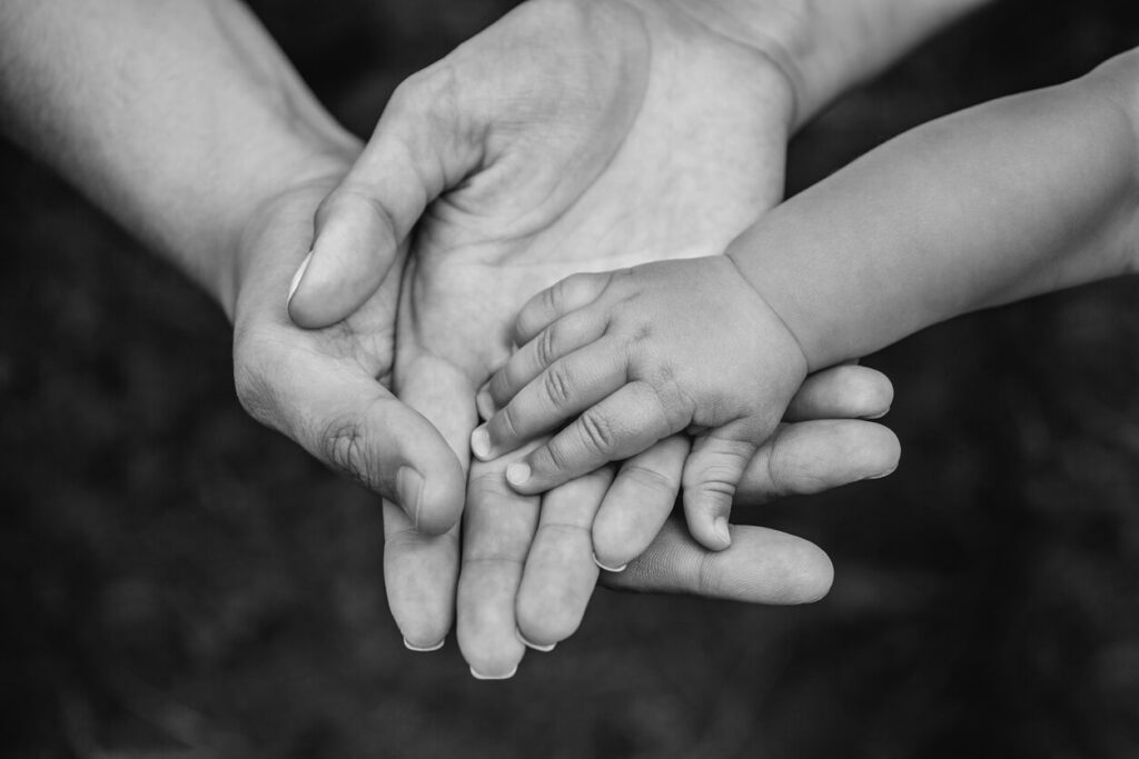 Separation agreement and children: a parent's open hands holding a small child's hand