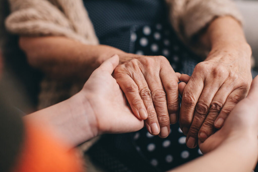 When to apply for special guardianship: an older woman’s hands held by a younger family member