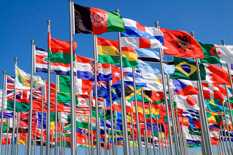 Proxy marriage and recognition: national flags of many countries flying against a blue sky