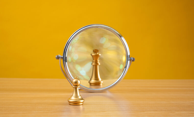 Divorcing a narcissist: a small gold pawn facing a mirror that reflects a gold king