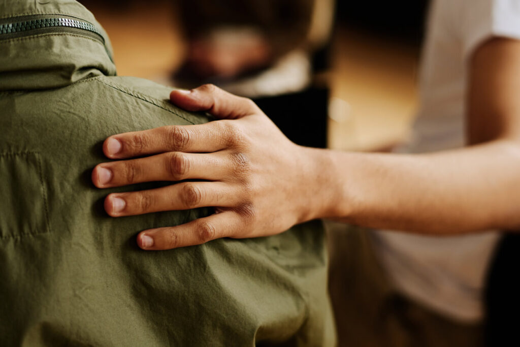 Gaslighting meaning explained: a friend's supportive hand resting on someone's shoulder