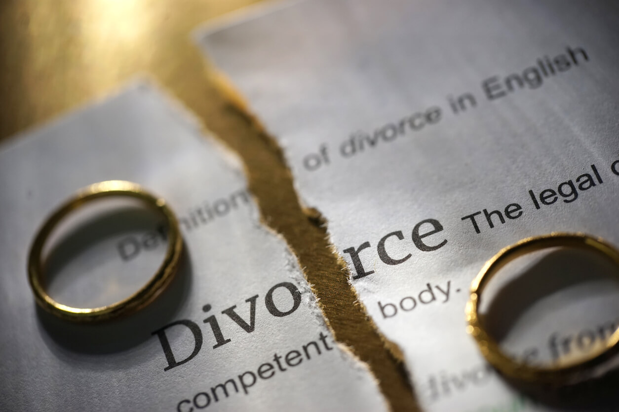 Clean break order after divorce: two wedding rings either side of a page torn in two