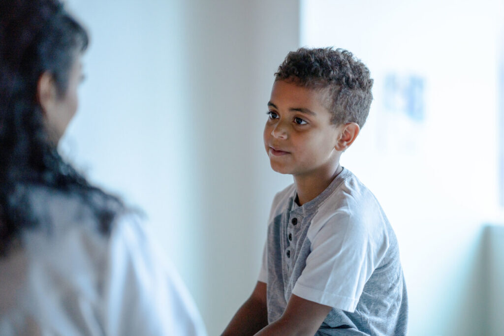Education supervision order: a boy listens closely as a parent talks with him at home